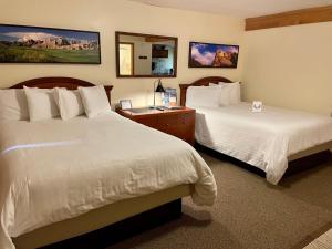 a hotel room with two beds and a mirror at Whitetail Creek Resort in Lead