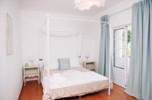 ValhascosにあるQuintinha do Quintasのベッドルーム(天蓋付き白いベッド1台付)