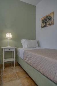 a bedroom with a bed and a table with a lamp at Patrinos Studios in Alikanas