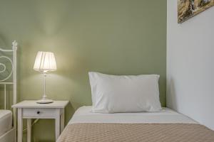 a bed with a white pillow and a lamp on a table at Patrinos Studios in Alikanas