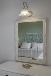 uno specchio su una parete sopra un letto in una stanza di Patrinos Studios ad Alikanás