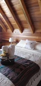 a bedroom with a large bed with a wooden ceiling at La Cabaña de Mari in Oxapampa