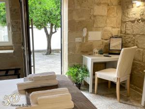 een kamer met een bureau en een tafel met een stoel bij 500 Home in Castrignano deʼ Greci