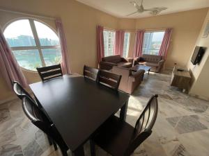 a living room with a table and chairs and a couch at Fullhouse Marina View Villas Apartment in Port Dickson