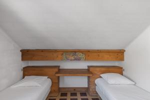 Habitación con 2 camas y estante de madera. en Appartement du Flocon - Welkeys en Megève