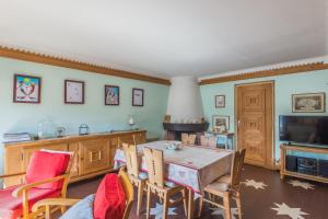 Appartement du Flocon - Welkeys في ميجيف: غرفة طعام مع طاولة وكراسي وتلفزيون