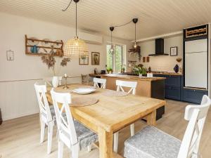 a kitchen and dining room with a wooden table and chairs at Holiday home Læsø LIII in Læsø