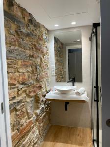 a bathroom with a stone wall and a sink at Hotel Boutique Berazadi Berri in Zarautz