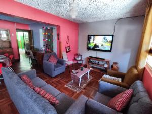 ein Wohnzimmer mit Sofas und einem Flachbild-TV in der Unterkunft Samayuna Wasi , entire apartment Cusco in Cusco