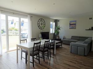 ein Wohnzimmer mit Tisch und Stühlen und einer Couch in der Unterkunft Comfortable Bungalow, Pink Granite Coast in Pleumeur-Bodou