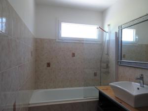 ein Badezimmer mit Waschbecken, Badewanne und Fenster in der Unterkunft Comfortable Bungalow, Pink Granite Coast in Pleumeur-Bodou + 16 Fotos