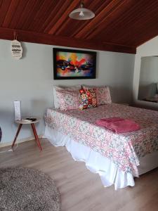 1 dormitorio con 1 cama grande con colcha y almohadas en Pousada La Casona, en Tibagi