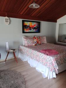 um quarto com uma cama grande com uma colcha e almofadas em Pousada La Casona em Tibagi
