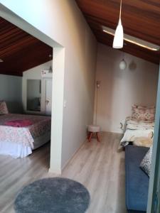 ein Zimmer mit 2 Betten und einem Sofa darin in der Unterkunft Pousada La Casona in Tibagi