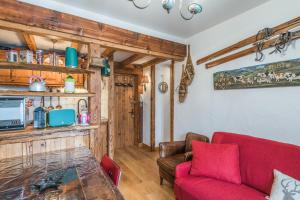 uma sala de estar com um sofá vermelho e uma mesa em Appartement de l'Alpage - Welkeys em Megève