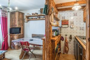 a kitchen with a table and a red chair at Appartement de l'Alpage - Welkeys in Megève