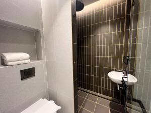 a small bathroom with a sink and a toilet at Citadines Connect City Centre Singapore in Singapore