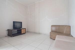 a living room with a chair and a television at KoolKost Syariah near Alun Alun Tasikmalaya (Minimum Stay 30 Nights) in Tasikmalaya