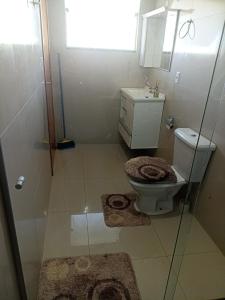 uma casa de banho com um WC, um lavatório e um espelho. em Kitnets RECANTO MAGRO em Olímpia