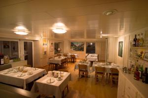 ein Esszimmer mit weißen Tischen und Stühlen in einem Restaurant in der Unterkunft Hotel Gerig in Wassen + 37 Fotos