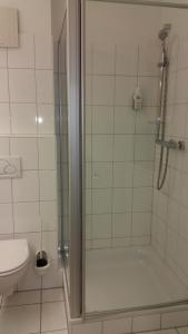 a bathroom with a shower and a toilet at Hotel Aquamarin in Papenburg