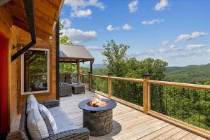 - une terrasse avec des chaises et un foyer extérieur dans une cabine dans l'établissement Red Sky Ridge cabin, à Sevierville