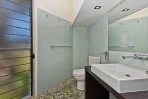 a bathroom with a white sink and a toilet at Tangalooma Hilltop Haven in Tangalooma +16 photos