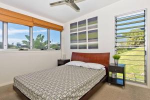 a bedroom with a bed and large windows at Tangalooma Hilltop Haven in Tangalooma
