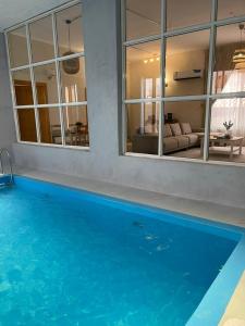 una piscina con agua azul en una casa en minivilla en Ash Shuwaybiţ
