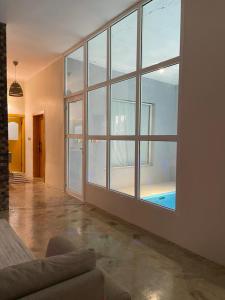 um quarto vazio com uma grande janela e um sofá em minivilla em Ash Shuwaybiţ