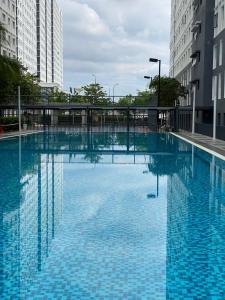 a large swimming pool in a city with tall buildings at Khadeeja Karisma in Semenyih