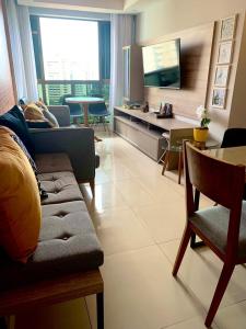 uma sala de estar com um sofá e uma mesa em Apartamento com estilo e conforto no Recife