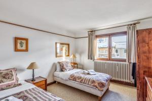 a bedroom with two beds and a window at Appartement Cœur du Village - Welkeys in Megève