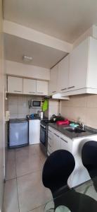 a kitchen with white cabinets and a black counter top at DaHause - Monoambiente en cañitas in Buenos Aires