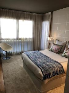 カンガス・デ・モラソにあるDuplex-Ático Cangas do Morrazoの大きなベッドと窓のある寝室
