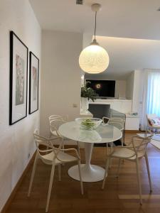 カンガス・デ・モラソにあるDuplex-Ático Cangas do Morrazoの白いテーブルと椅子のあるダイニングルーム