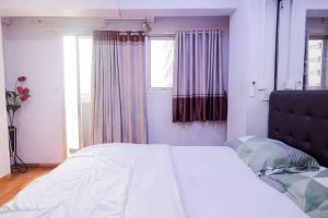 een slaapkamer met een groot wit bed en een raam bij Apartemen Sentra Timur Residence - Fortune 88 Tower Orange in Jakarta