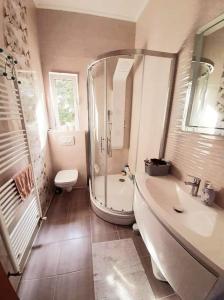 y baño con ducha, bañera y lavamanos. en Apartmani 'Mirijana Gabrić' A3, en Lopar