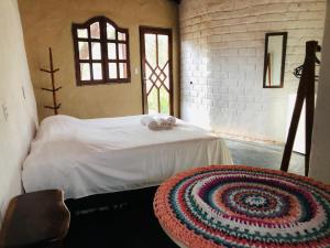 a bedroom with a bed with a rug on it at Shanti - Hospedaria na Vila de São Jorge in Sao Jorge