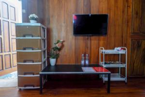 - un salon avec une table et une télévision dans l'établissement RedDoorz Syariah near Terminal Mendolo Wonosobo 2, à Ngasinan