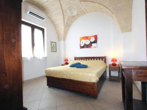 1 dormitorio con cama, mesa y ventana en Characteristic apartments in Salento just a few minutes from the sea, en Diso