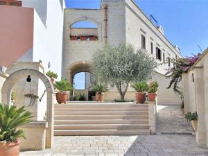 un edificio con escaleras y macetas. en Characteristic apartments in Salento just a few minutes from the sea, en Diso