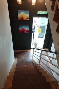 a staircase in a building with paintings on the wall at OYO 89908 Hotel Kensington in Sandakan