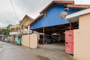 un edificio azul con una furgoneta estacionada frente a él en Asokatama Residence Syariah Mitra RedDoorz en Padang