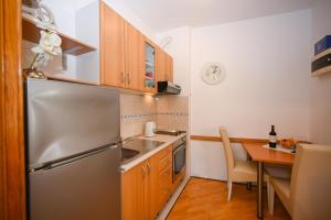 una cucina con frigorifero in acciaio inox e tavolo di Apartment La Rocca a Dubrovnik Altre 37 foto