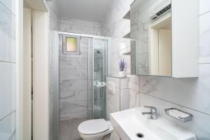 een badkamer met een toilet, een wastafel en een douche bij Apartments Green Garden in Dubrovnik