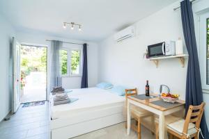 een kleine kamer met een bed en een tafel bij Apartments Green Garden in Dubrovnik