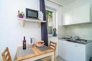 een keuken met een tafel en een fruitschaal bij Apartments Green Garden in Dubrovnik