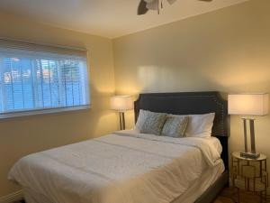 ein Schlafzimmer mit einem Bett mit zwei Lampen und einem Fenster in der Unterkunft Enjoy Big Charming House in Paradise Hills San Diego in San Diego