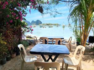 a table and chairs with a view of the water at Aquing's Place in El Nido